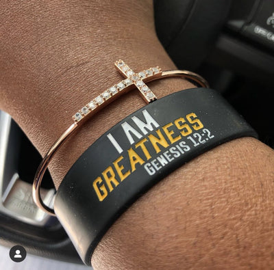 I AM Greatness wristband in black, white, and gold lettering.